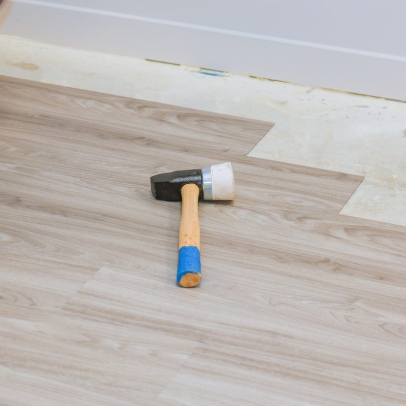 Carpenter installing floor installation laminate wood texture floor of new home improvement Carpenter installing floor installation laminate wood texture floor of new home improvement
