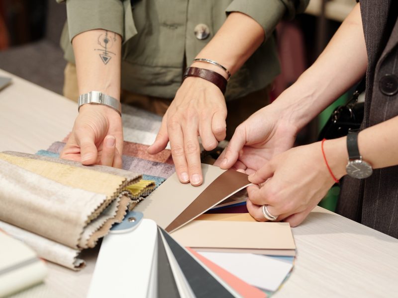 Hands of young manager of studio of interior design consulting customer