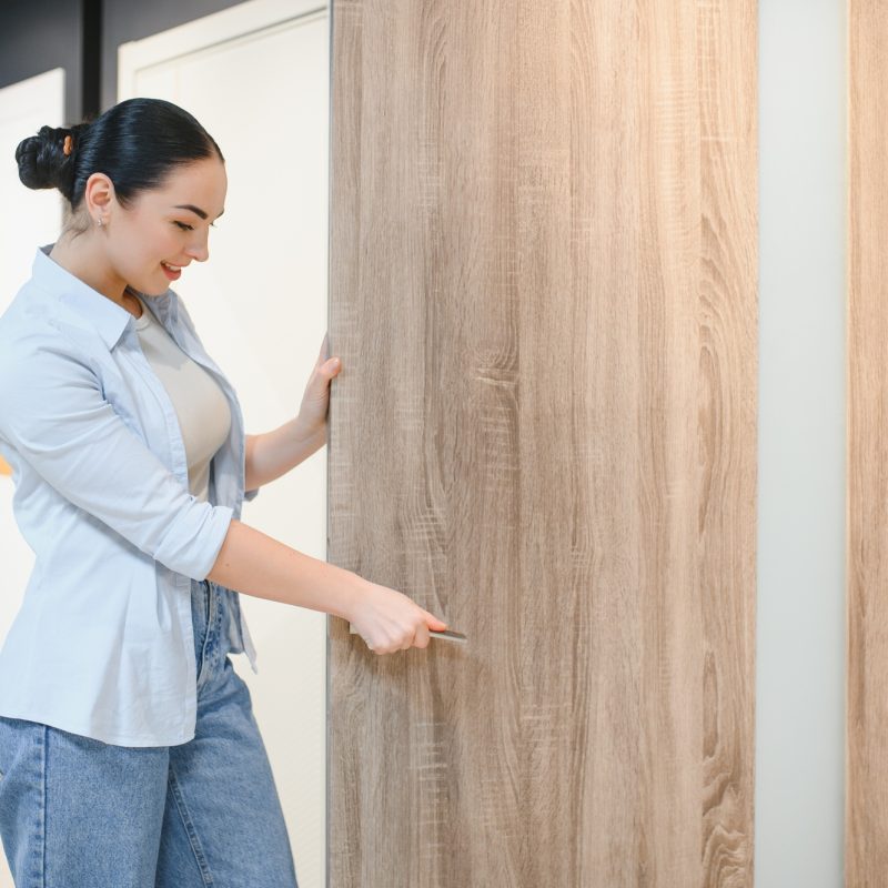 Woman choosing interior wooden door in a showroom Woman choosing interior wooden door in a showroom
