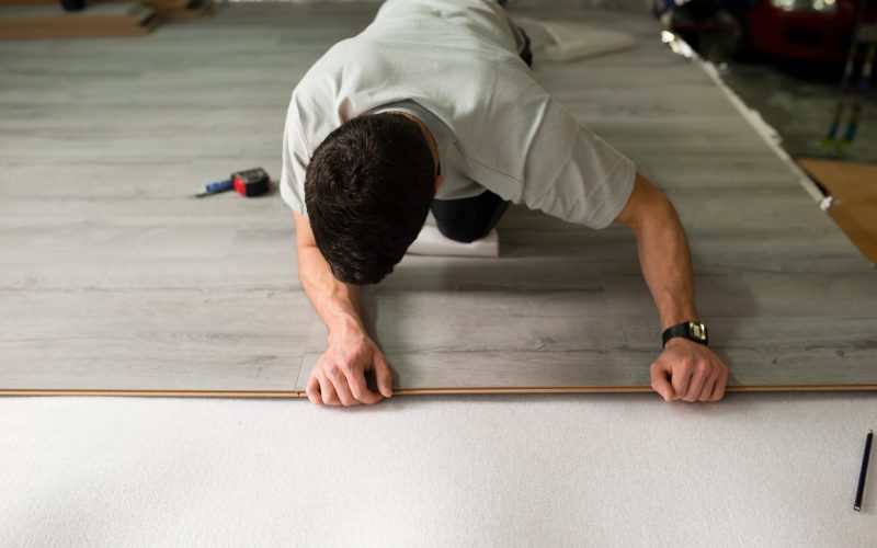 Young man placing a laminate floor