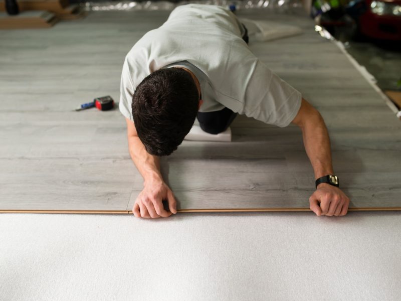 Young man placing a laminate floor